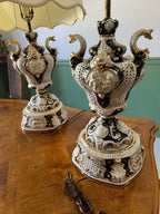 Baroque Porcelain Table Lamps Pair Ornate Cherub Motif Black White Gold Embellished Romantic Rococo Style Sculptural Lighting Decoration